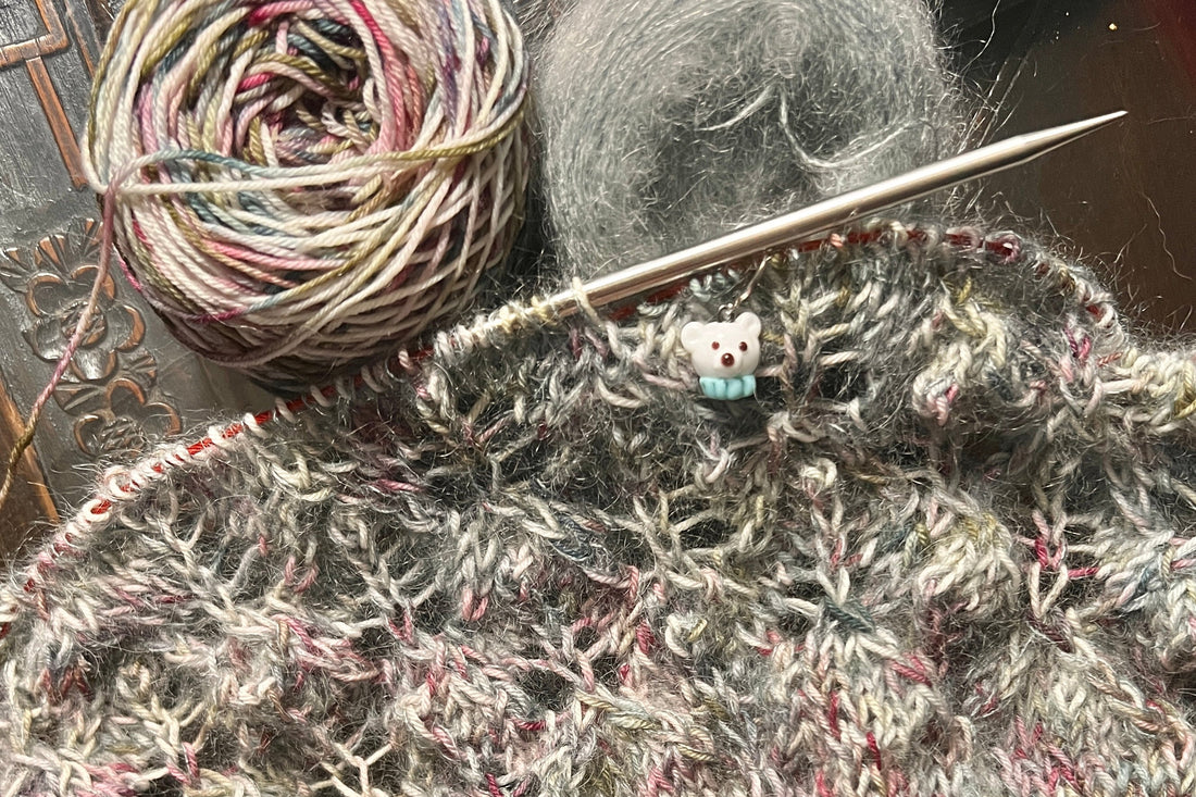 knitting on needles with a polar bear stitch marker