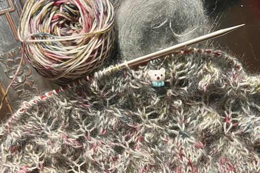 knitting on needles with a polar bear stitch marker