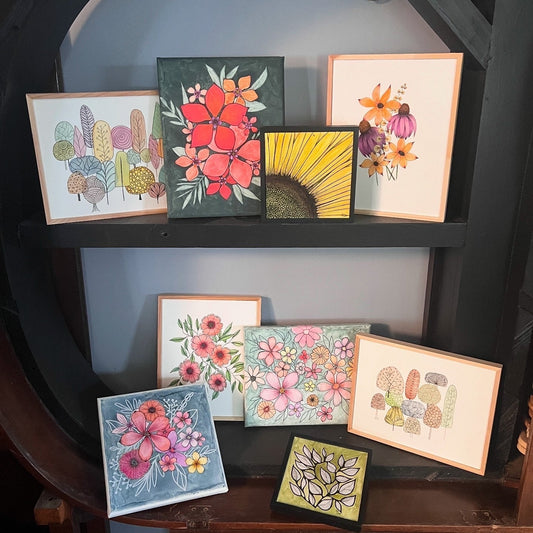 arrangement of watercolor paintings on a shelf