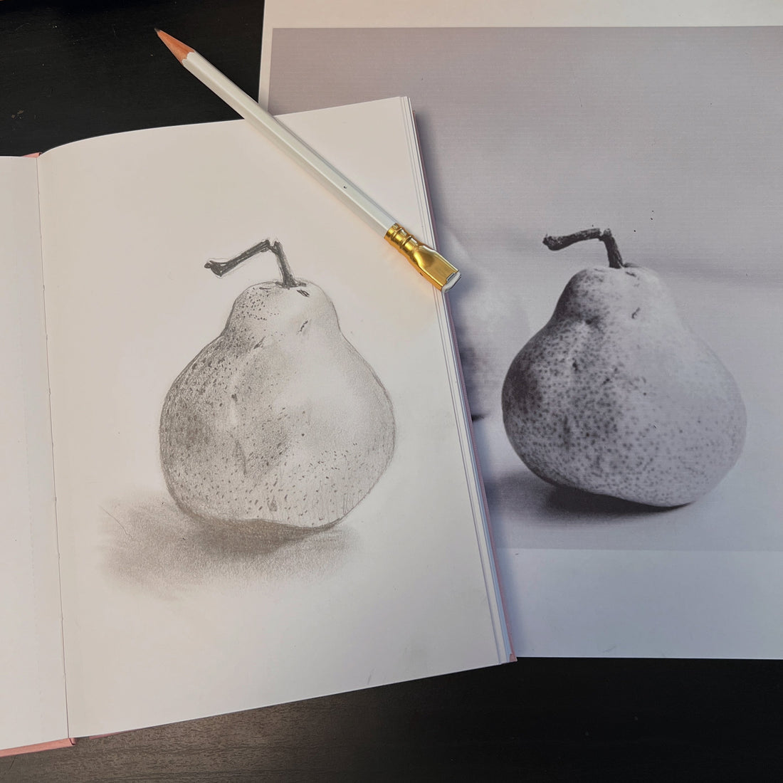 pencil sketch of a pear in a sketchbook